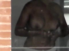 Busty woman filmed in secret while naked next to the window