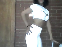 Sia in all white dancing, doing hair and playing with weights