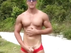 Blond guy flexing in speedo and takes his cock out