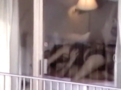 Voyeur zooms on sex in a hotel room