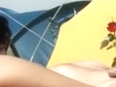 Il masse les belles fesses de sa femme sur la plage