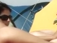 Il masse les belles fesses de sa femme sur la plage