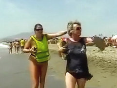 Mature Spanish nudists walk around the beach completely naked