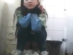 Asian girl pulls down her tight jeans to pee